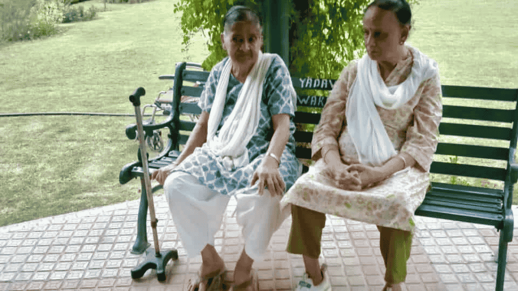 Two elderly women sitting in a park and discussing the future of elderly care homes in India