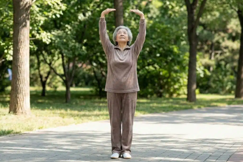Older woman gently raising both arms overhead in the “touch the sky” movement to stretch the body and improve posture
