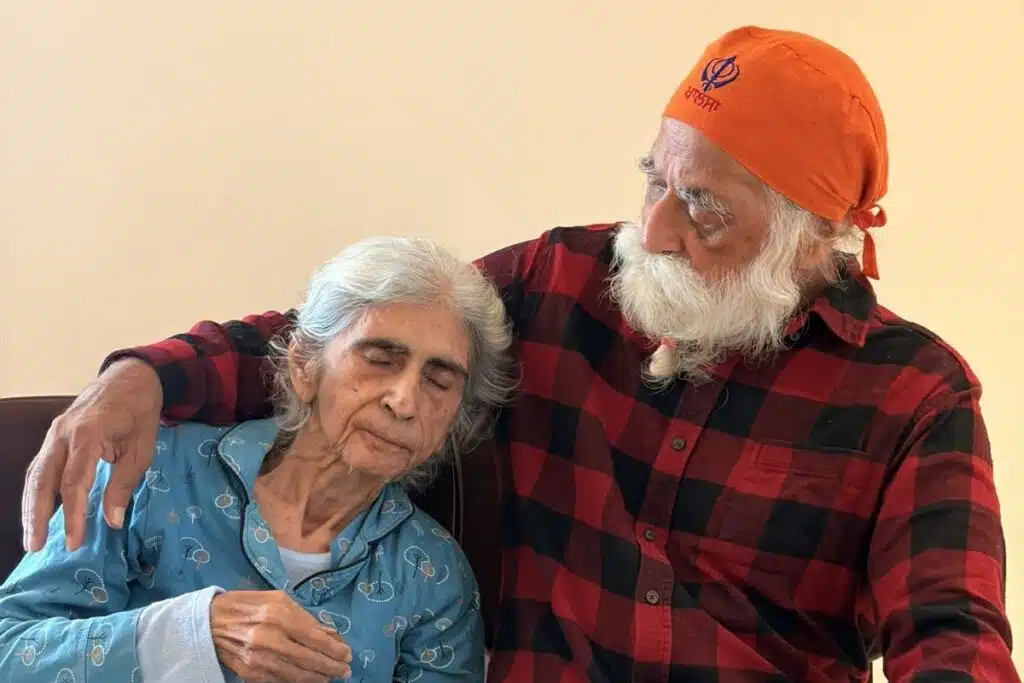An elderly Indian couple in Delhi NCR, sitting close together in a moment of quiet comfort