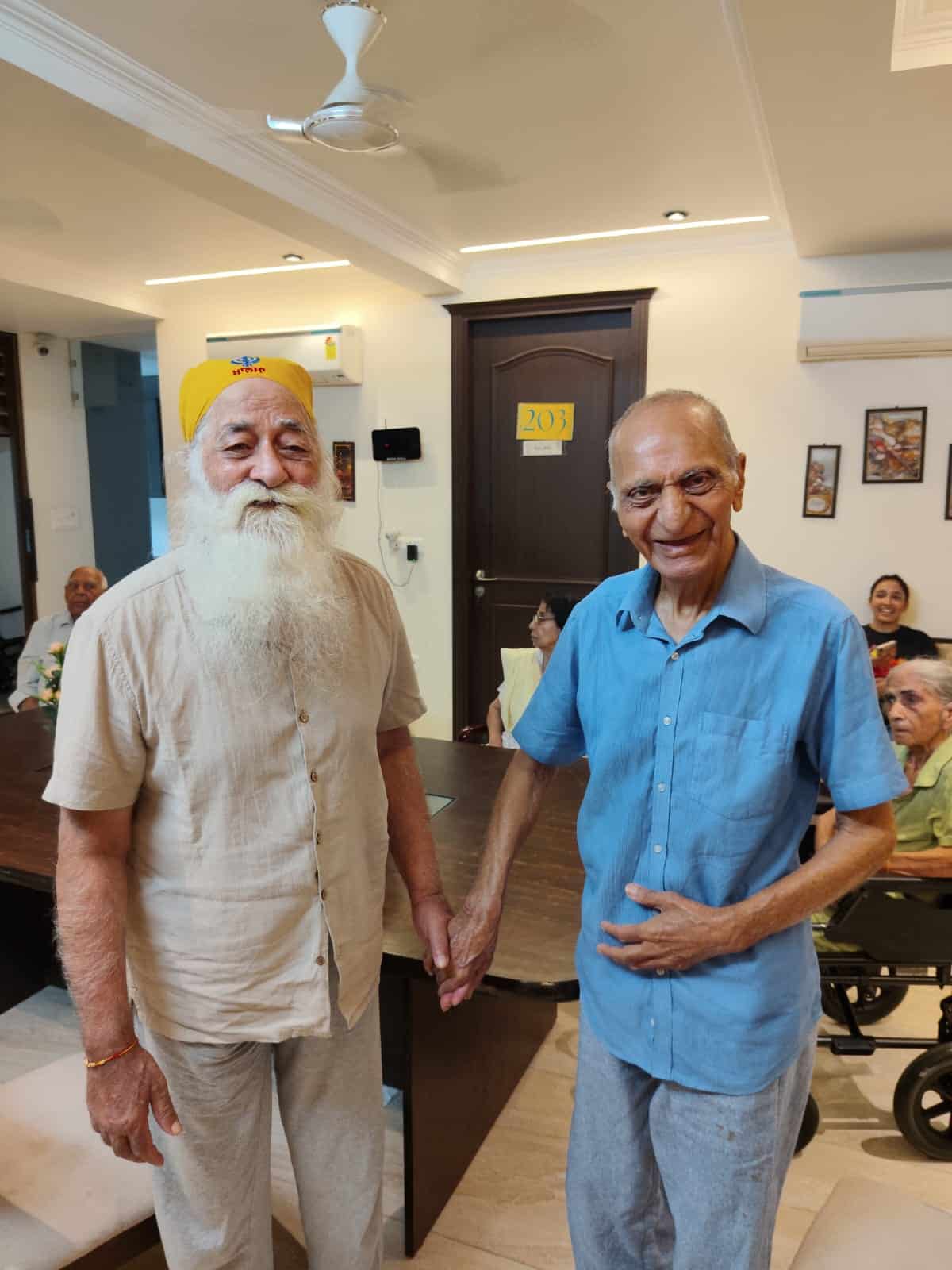 Two residents holding hands and smiling together at Gracias Living in Gurgaon