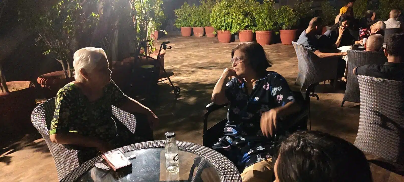 Senior residents chatting at a rooftop night party at Gracias Living in Gurgaon