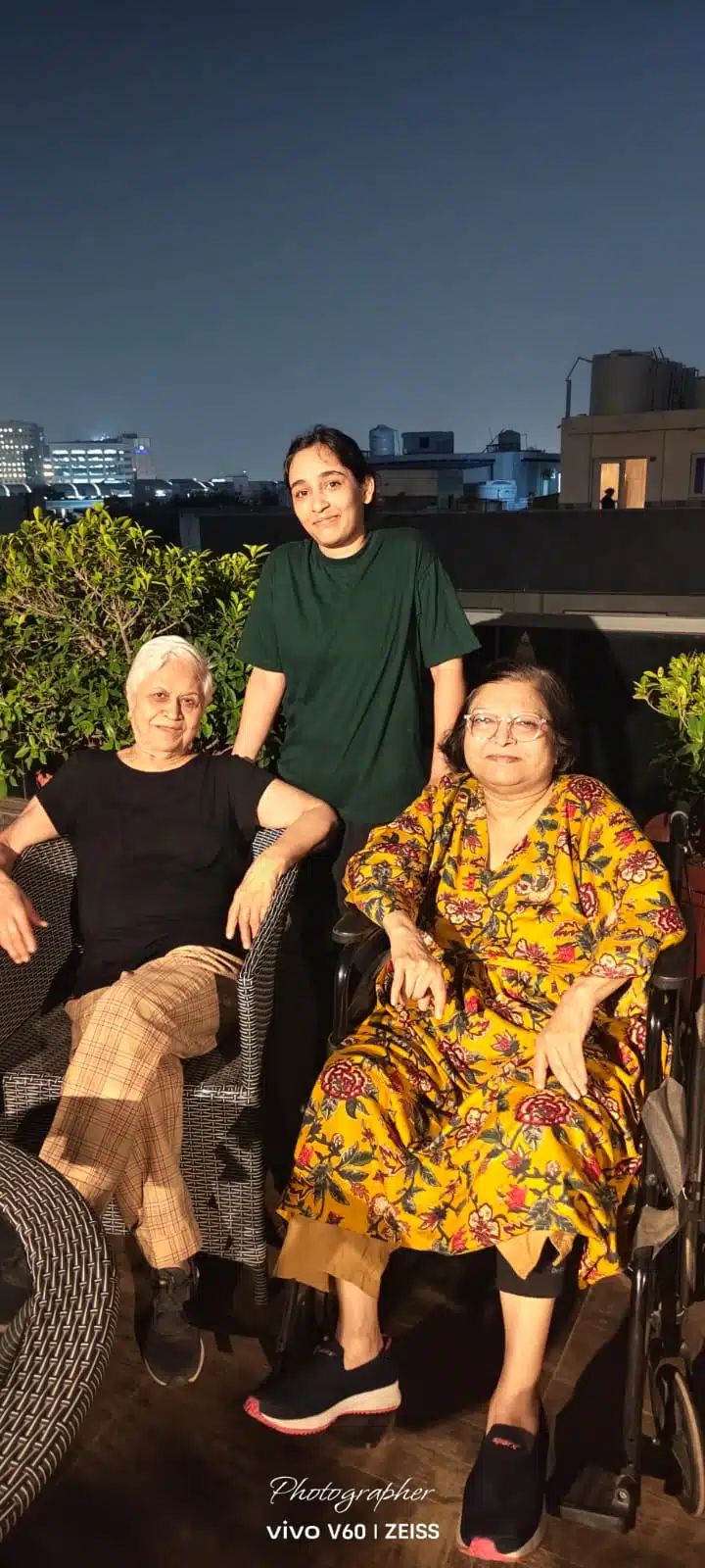 Two senior residents and a caretaker on the rooftop during a night party at Gracias Living, Gurgaon